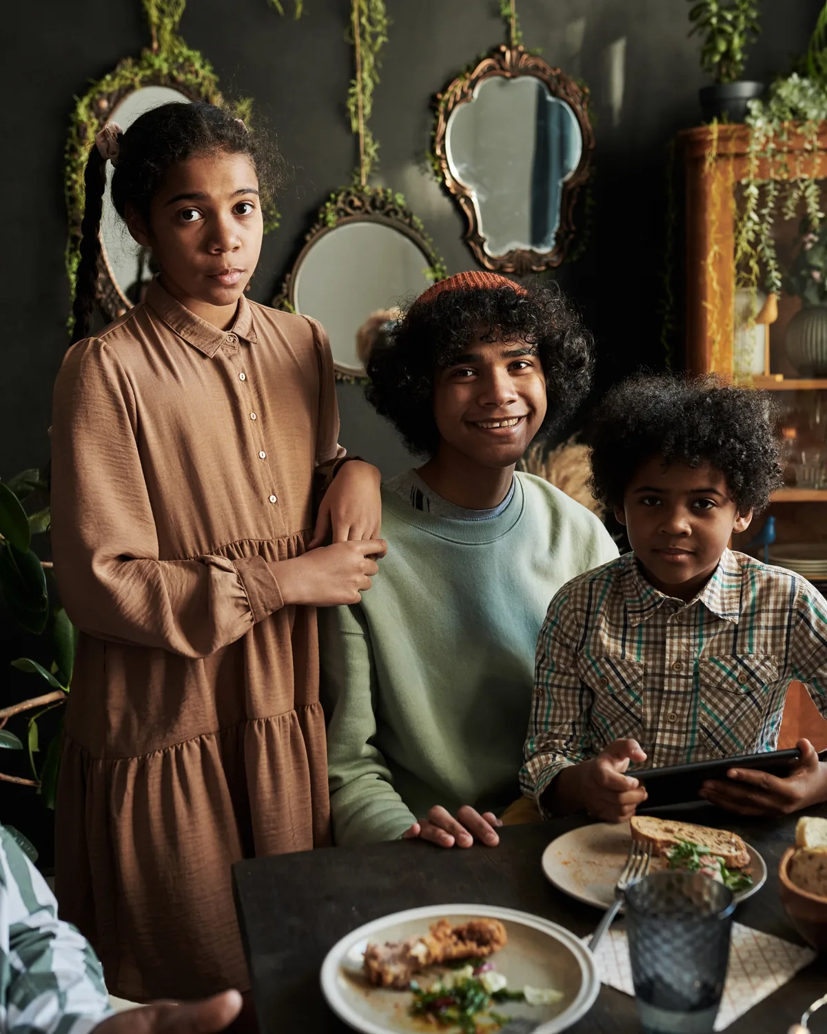 Three siblings at a family dinner table.